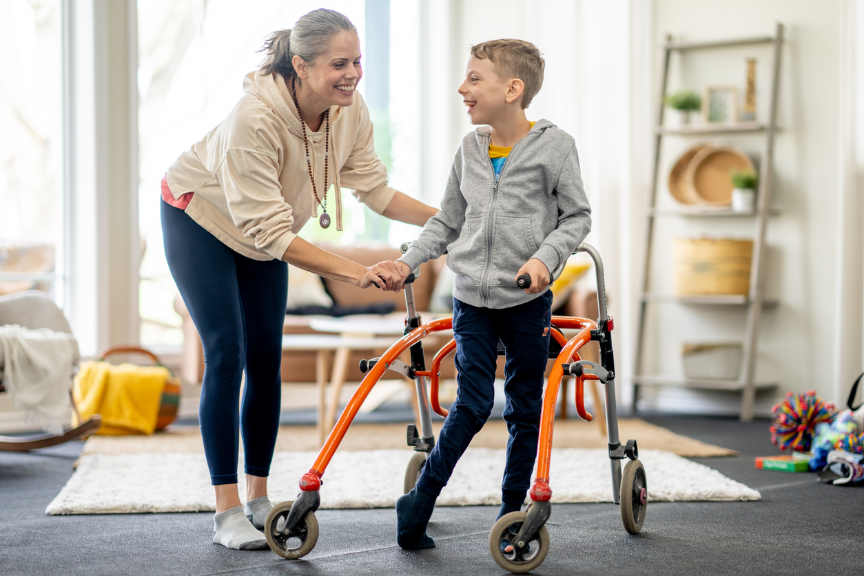 Caregiver helping child with walker